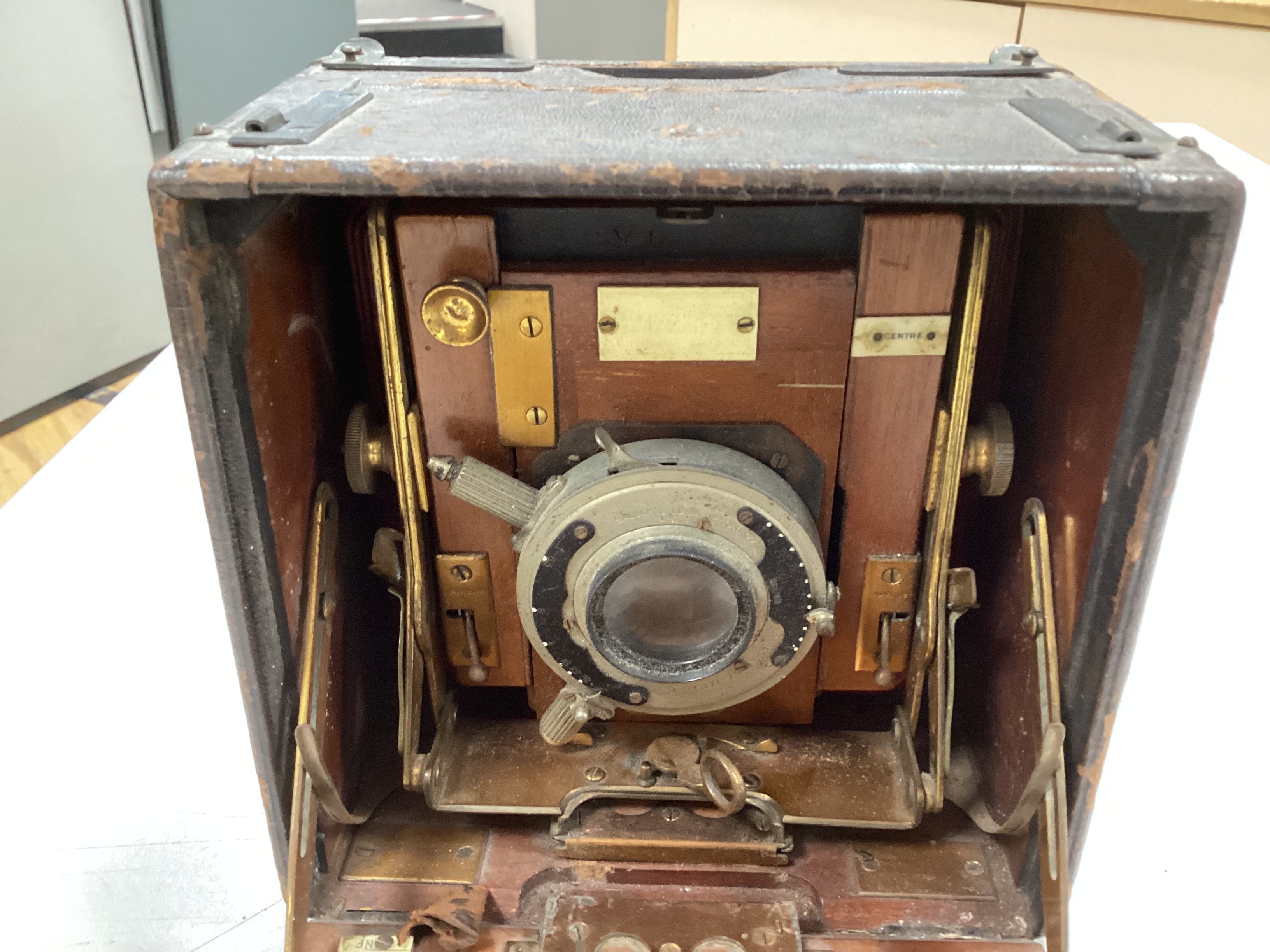 An Edwardian quarter plate camera, an early 20th century gilt decorated metal and Bakelite telephone, two Edwardian car lamps and a hand lamp etc.